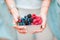 Closeup berries fruits at female hands. Blueberries, raspberries, strawberries, cherries and blackberries on the market