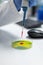 Closeup of biologist researcher man hands dropping red liquid in petri dish