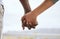 Closeup of biracial couple interlocking fingers and holding hands while bonding outdoors. Caring mixed race woman united