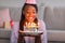Closeup of black birthday woman holding cake