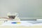 Closeup black coffee in transparent cup of coffee with work paper and pencil and eyeglasses on blurred wooden desk and frosted gla