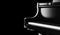 Closeup black grand piano isolated on black