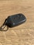 Closeup of a black keychain with buttons on it on a wooden table