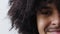 Closeup of a black man with curly afro hair smiling and laughing at the camera. Portrait of a cool and young african man