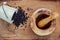 Closeup black pepper in wooden box with mortar and pestle on shabby teak wood table. Seasoning and species ingredients concept .