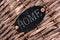 Closeup of a black plaque with a writing "Home" on a wicker surface