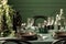 Closeup of black plates, flowerpot and water bottles on dining room table with green tablecloth