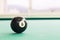 Closeup black snooker billards ball on table with green surface