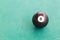 Closeup black snooker billards ball on table with green surface