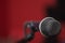 Closeup black vocal microphone mounted on mic stand, blurry red dark bcakground