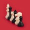 Closeup of black and white chess pieces lined up on a bright red background- teamwork, diversity