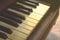 Closeup of black and white piano keys and wood grain with vintage tone