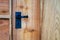 Closeup of black wrought iron door handle on waney edge wooden shed door.