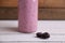 Closeup of blackberries on a wooden table with a bottle of smoothie on the background