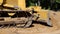 Closeup of blade and track of a working bulldozer as it pushes dirt.