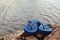 Closeup Of Blue Flip Flops On Rocky Beach At Summer Time