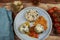 Closeup of blue plate on wood table with homemade minced meat balls gratinated with mozzarella cheese in fresh tomato sauce with