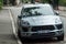 Closeup of blue Porsche Macan on front view parked in the street