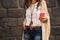 Closeup on boho young woman near stone wall writing sms