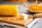 Closeup on boiled corn and butter on cutting board