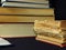 Closeup of books pile. A pile of old books is pictured against dark black background. Old books stacked in a pile.