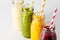 Closeup bottles with fruit smoothies. Healthy detox drinks, bright background