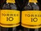 Closeup of bottles with logo lettering of spanish brandy torres 10 in shelf of german supermarket