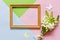 Closeup of the bouquet of white flowers, wooden frame and silhouettes of butterflies on the Pastel colors background