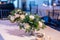 Closeup of bouquets in vases on the table under the lights in a restaurant