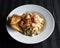 Closeup of a bowl of creamy pasta with shrimps and potatoes on the table