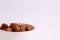 Closeup of a bowl of dried palm fruits isolated on a white background