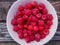 Closeup of bowl of fresh and ripe rasberries on wooden table. natural food.Ripe tasty berries.Natural vitamins. organic