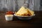 Closeup bowl of nacho chips with salsa and cheese