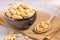 Closeup of a bowl of peanuts on a sackcloth on top of a wooden surface