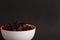 Closeup of a bowl of raisins isolated on a black background