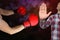 Closeup boxer strikes in red boxing gloves, man stops with a gesture of his hand, STOP, on dark purple background, copy space