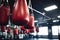 closeup of boxing gloves hanging in a brightly lit gym