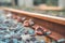 Closeup Bracket for railway tracks with concrete sleepers and rubble