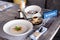 Closeup breakfast with porridge and Turkish coffee in cezve on wooden stand, porcelain cup with sugar cubes served table in res