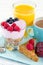Closeup of breakfast with yoghurt, berries, juice, toast and coffee