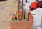 Closeup of a Bricklayer Worker Installing Red Blocks. Bricklaying.