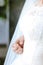 Closeup bridal dress and hand.