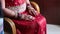 Closeup Bride on Chair Holds Hands with Henna Patterns on Knees