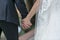 Closeup of a bride and groom holding hands