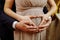 Closeup of bride and groom making heart hands