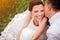 Closeup bride smiling while groom whispering compliments to her