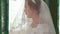 Closeup Bride in White Lacy Dress under Veil Smiles