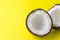 Closeup of broken coconut on brigth yellow background