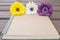 Closeup brown note book with colorful faked flower on blurred old wood table textured background