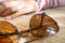 Closeup of brown sunglasses on the table belonging to teen girl. Juvenile fashion lifestyle